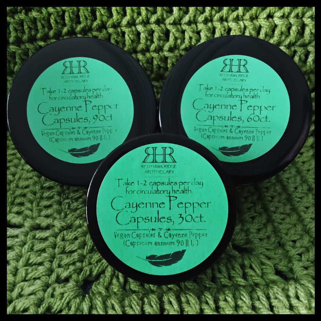 Three containers of Cayenne Pepper Capsules on a green textured background